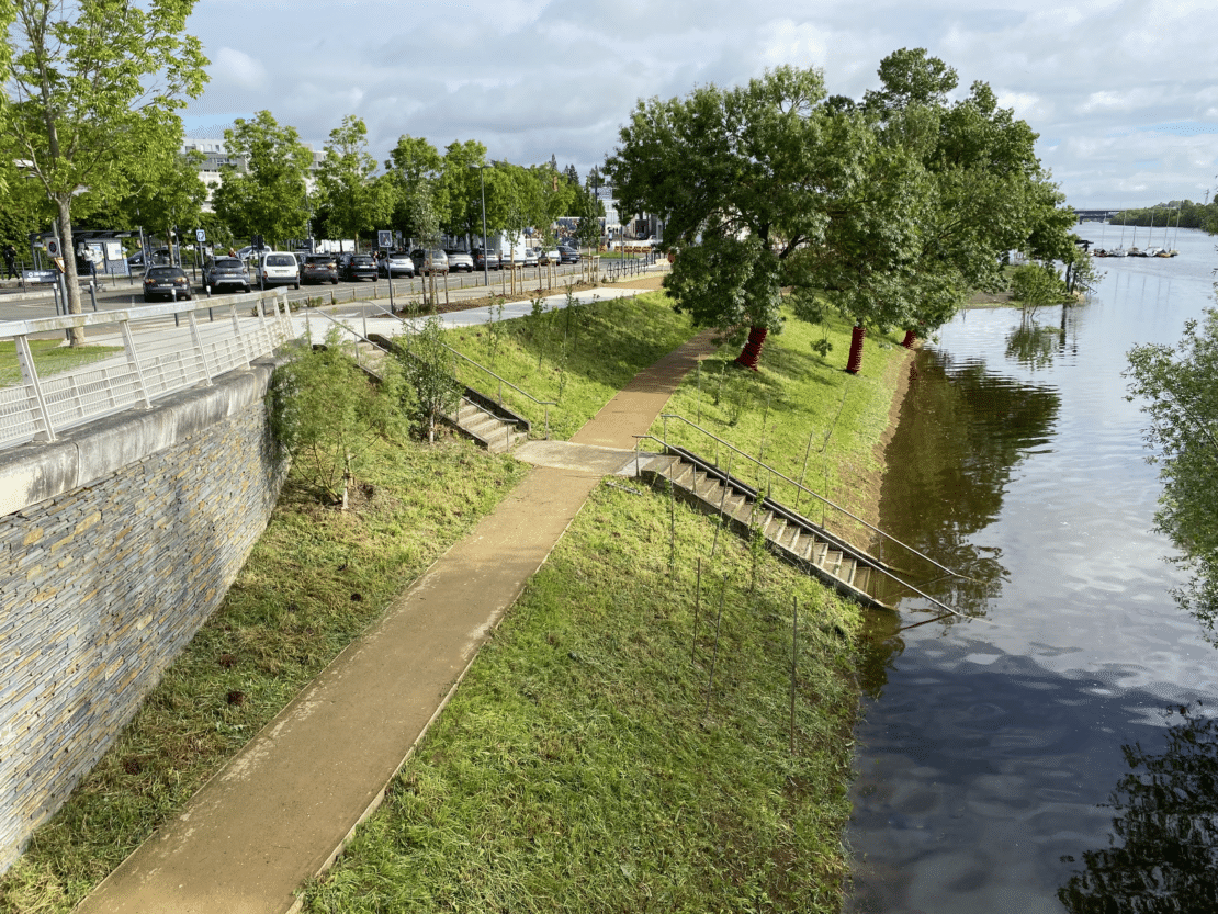 Mon image favorite : Les aménagements sont ici présentés sous un jour idyllique. c'est une photo prise d'un point de vue en hauteur. Le nouveau sentier, ponctué d'escaliers, occupe le centre de l'image ; il s'élève vers la route à gauche et rejoint les berges sur la droite, offrant ainsi une vue dégagée sur l'ensemble du site.